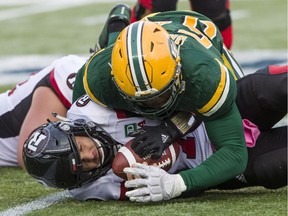 Ottawa Redblacks quarterback Trevor Harris (7) gets sacked by the Edmonton Eskimos' Alex Bazzie on Saturday, Oct. 13, 2018.