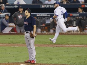 Boston Red Sox pitcher Nathan Eovaldi watches the ball leave the park as Max Muncy of the Los Angeles Dodgers hits an 18th inning walk-off home run to win Game 3 of the 2018 World Series at Dodger Stadium on Oct. 26, 2018 in Los Angeles.