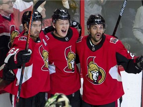 The Ottawa Senators' Brady Tkachuk (centre) celebrates his goal with teammates Mark Stone, left, and defenceman Dylan DeMelo on Monday, Oct. 15, 2018 in Ottawa. Tkachuk was playing with a torn ligament in his left leg.