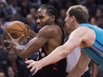 Toronto Raptors forward Kawhi Leonard, left, drives past Charlotte Hornets forward Cody Zeller during second half NBA basketball action in Toronto on Monday, Oct. 22, 2018. (THE CANADIAN PRESS/Nathan Denette)