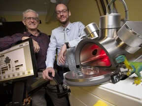 Professors Maikel Reinstadter, right, and Ralph Pudritz pose for a photo with the planet simulator in the origins of life lab at McMaster University in Hamilton, Ont., Wednesday, Oct. 3, 2018.