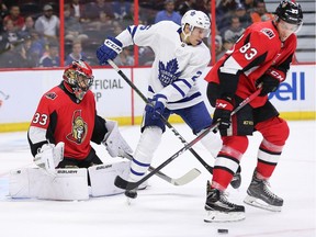 Goalie Mike McKenna keeps his eye on the puck as Par Lindholm (C) and Christian Jaros (R) battle for position in period two as the Ottawa Senators face the Toronto Maple Leafs at the Canadian Tire Centre in Pre-season NHL action.