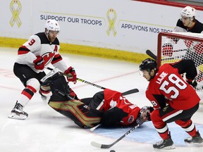 Ottawa Senators goaltender Craig Anderson takes a tumble as teammate Maxime Lajoie clears the puck during Tuesday's game against the New Jersey Devils. (THE CANADIAN PRESS)