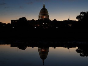 The U.S. Capitol is reflected in a puddle of water a day after Americans voted in the midterm elections, on November 7, 2018 in Washington, D.C.