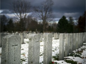 Grave markers stand amid Saturday's light snowfall at the National Military Cemetery in the Beechwood Cemetery.  Ashley Fraser/Postmedia