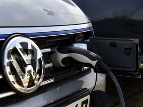 In this file photo taken on February 02, 2016 A VW electric car is plugged on a power station at a Service station in Berlin. - Volkswagen on November 16, 2018 announced plans to invest up to 44 billion euros ($ billion) into the greener, smarter cars of the future as the car giant seeks to turn the page on its "dieselgate" emissions cheating scandal.