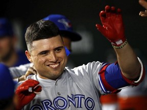 Toronto Blue Jays' Aledmys Diaz high-fives teammates in the dugout after hitting a solo home run in the ninth inning of a baseball game against the Baltimore Orioles in Baltimore on September 17, 2018.