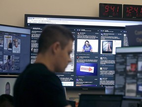 In this Oct. 17, 2018 file photo, a man works at his desk in front of monitors during a demonstration in the war room, where Facebook monitors election related content on the platform, in Menlo Park, Calif.