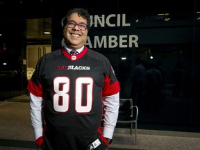 Calgary mayor Naheed Nenshi wears an obligatory smile while also wearing an Ottawa Redblacks jersey at City Hall in Calgar on Dec. 5, 2016. He was making good on a bet with Ottawa Mayor Jim Watson in the wake of the Redblacks beating the Calgary Stampeders in the Grey Cup eight days earlier.