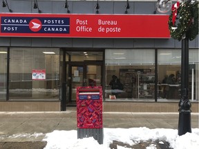 Christmas decorations adorn a lamppost outside a post office in downtown Ottawa on Monday.