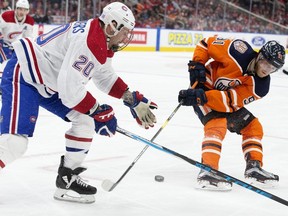 Oilers' Drake Caggiula (91) battles Canadiens' Nicolas Deslauriers (20) during third period NHL action at Rogers Place, in Edmonton on Nov. 13, 2018.