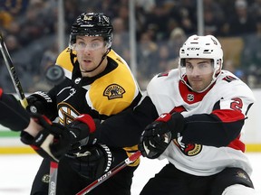 Bruins’ Sean Kuraly (left) and Senators’ Dylan DeMelo chase the puck during a game in Boston. DeMelo is one of three Sens facing his former Sharks team. (AP FILE)