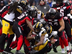 Hamilton Tiger-Cats Frankie Williams (37) is tackled while taking on the Ottawa Redblacks during first half CFL East Division final action in Ottawa on Sunday.