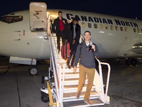 Quarterback Trevor Harris leads a group of Redblacks off the plane after the team's charter flight arrived in Edmonton on Tuesday.