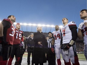 Governor General of Canada Julie Payette does the coin toss as Calgary Stampeders quarterback Bo Levi Mitchell (19) and Ottawa Redblacks quarterback Trevor Harris (7) look on during the 106th Grey Cup at Commonwealth Stadium in Edmonton, Sunday, November 25, 2018.
