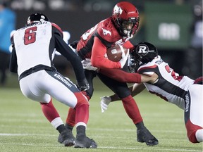 Ottawa Redblacks defensive back Antoine Pruneau (6) and defensive back Corey Tindal (28) tackle Calgary Stampeders running back Terry Williams (38) during the second half of the 106th Grey Cup in Edmonton, Alta. Sunday, Nov. 25, 2018.