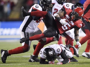 Calgary Stampeders running back Don Jackson (25) gets tackled by Ottawa Redblacks defensive back Jonathan Rose (9) during the first half of the 106th Grey Cup at Commonwealth Stadium in Edmonton, Sunday.