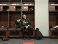 Redblacks quarterback Trevor Harris checks his phone after participating in a media interview in teh locker room at TD Place stadium on Tuesday.