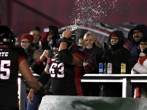 Ottawa Redblacks offensive lineman Jon Gott (63) smashes a beer can on his helmet after chugging it, as he celebrates his team's touchdown against the Toronto Argonauts during second half CFL football action in Ottawa on Friday, Nov. 2, 2018. THE CANADIAN PRESS/Justin Tang ORG XMIT: JDT108