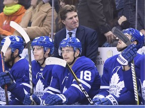 Coach Mike Babcock stands behind his players on the Toronto Maple Leafs' bench.