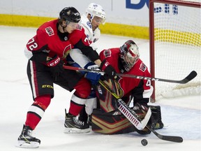 Ottawa Senators defenceman Thomas Chabot ties up Tampa Bay Lightning right wing Ryan Callahan as Sens goaltender Craig Anderson reaches for the puck during third period NHL action in Ottawa, Sunday, Nov. 4, 2018. The Lightning defeated the Senators in overtime.