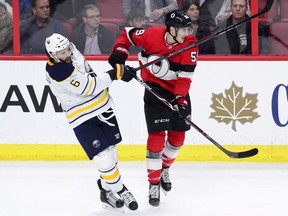 The Ottawa Senators' Alex Formenton tries to avoid being hit by the stick of Buffalo Sabres defenceman Marco Scandella in Ottawa on Thursday, Nov. 1, 2018.