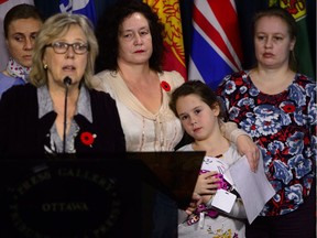 Green Party Elizabeth May, left, at a press conference on Oct. 30, calling on the government to intervene in the case of Elena Musikhina, with granddaughter Iaroslava Sunatori, 8, and daughter Olesia Sunatori.
