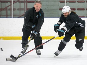 San Jose Shark Erik Karlsson and assistant coach Rob Zettler take part in a drill as the former Senators captain practises at the University of Ottawa athletic facility in advance of his first game against his old team at the Canadian Tire Centre on Saturday.