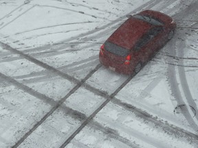 A motorist drives though a slick intersection.