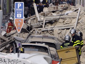 Firefighters work at the scene where a building collapsed In Marseille, southern France, Monday, Nov. 5, 2018.