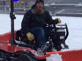 Ottawa Redblacks player, Jon Gott, clearing snow at TD Place.