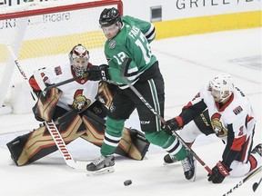Senators netminder Craig Anderson eyes the puck behind the traffic created by defenceman Dylan DeMelo, right, and Stars forward Radek Faksa during the first period of Friday's game in Dallas.