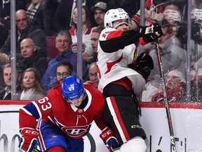 Zack Smith is driven into the boards by the Canadiens' Matthew Peca on Tuesday night. Smith is happy that he no longer has to deal with a full-cage mask following an injury, but he's not sure if he'll keep playing with the half-visor.