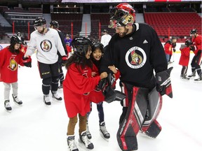 Mike McKenna holds up kids from St. Michael Catholic School and D. Roy Kennedy Public School during the 15th annual Eugene Melnyk Skate for Kids at Canadian Tire Centre on Thursday, Dec. 20, 2018.
