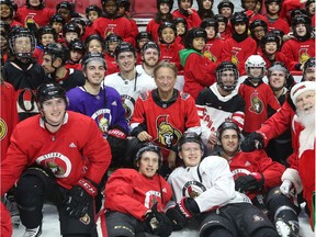 Senators owner Eugene Melnyk in the middle of a large group of NHL team players and Ottawa-area students during the Eugene Melnyk Skate for Kids at Canadian Tire Centre on Thursday.