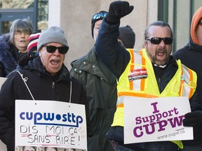 Allies of postal workers, including CUPW Local 580 president Ian Anderson (yellow vest), protest outside the Canada Post annual meeting in Ottawa. December 12, 2018.