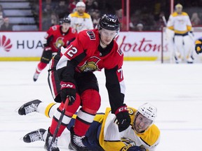 Nashville Predators centre Colton Sissons (10) hits the ice as Senators defenceman Thomas Chabot knocks him off the puck during first-period action in Ottawa on Monday, Dec. 17, 2018. (THE CANADIAN PRESS)
