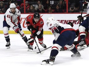 Ottawa Senators left wing Ryan Dzingel (18) tries to control the puck between Washington Capitals right wing Tom Wilson (43) and defenceman Dmitry Orlov (9) during second period NHL hockey action in Ottawa, Saturday December 29, 2018.