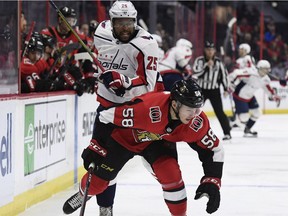 Washington winger Devante Smith-Pelly knocks Ottawa defenceman Maxime Lajoie off balance during a battle for the puck during Saturday's game. The Capitals won 3-2.
