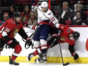 Senators rookie winger Brady Tkachuk gets wrapped up by Capitals defenceman Madison Bowey along the boards during Saturday's game at Canadian Tire Centre.