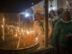 Christian worshippers light candles at the Church of the Nativity, traditionally recognized by Christians to be the birthplace of Jesus Christ, in the West Bank city of Bethlehem, Sunday, Dec. 23, 2018.