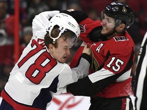 Ottawa Senators left wing Zack Smith (right) knocks off the helmet of Washington Capitals defenceman Tyler Lewington on Saturday. THE CANADIAN PRESS