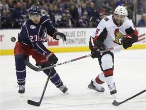 Senators defenceman Cody Ceci, right, backhands a shot on net past the Blue Jackets' Ryan Murray in December, 2018