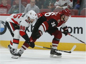 Defenceman Christian Wolanin tries to poke the puck away from Coyotes winger Christian Fischer during a game with the Senators in late October.