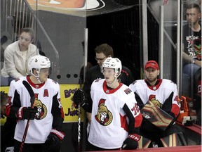Senators goaltender Craig Anderson, right, sits on the bench being teammates Mark Borowiecki, left, and Thomas Chabot after being replaced in goal by Mike McKenna for the third period of Frida's game against the Devils in New Jersey