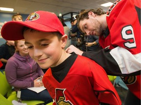Bobby Ryan signs an autograph on the back of Dominic Daoust, 7, as the Ottawa Senators made their annual Christmas visit to the Children's Hospital of Eastern Ontario (CHEO) on Wednesday, Dec. 19.