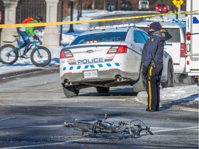 A cyclist rides past the scene near Lemieux Island after a cyclist died after he was struck by a taxi on the Sir John A. Macdonald Parkway early Friday morning.