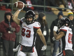 Redblacks wide receiver Julian Feoli-Gudino (left) spikes the ball after scoing a touchdown during the first half of the Grey Cup against the Calgary Stampeders. Feoli-Gudino was re-signed by Ottawa on Tuesday. (Jason Franson/The Canadian Press)