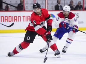 Ottawa Senators defenceman Dylan DeMelo moves the puck away from Montreal Canadiens left wing Paul Byron during second period NHL hockey action in Ottawa on Thursday, Dec. 6, 2018.