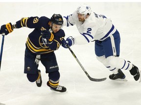 Buffalo Sabres forward Zemgus Girgensons (28) skates around Toronto Maple Leafs defenseman Ron Hainsey (2) during the first period of an NHL hockey game, Tuesday, Dec. 4, 2018, in Buffalo, N.Y.